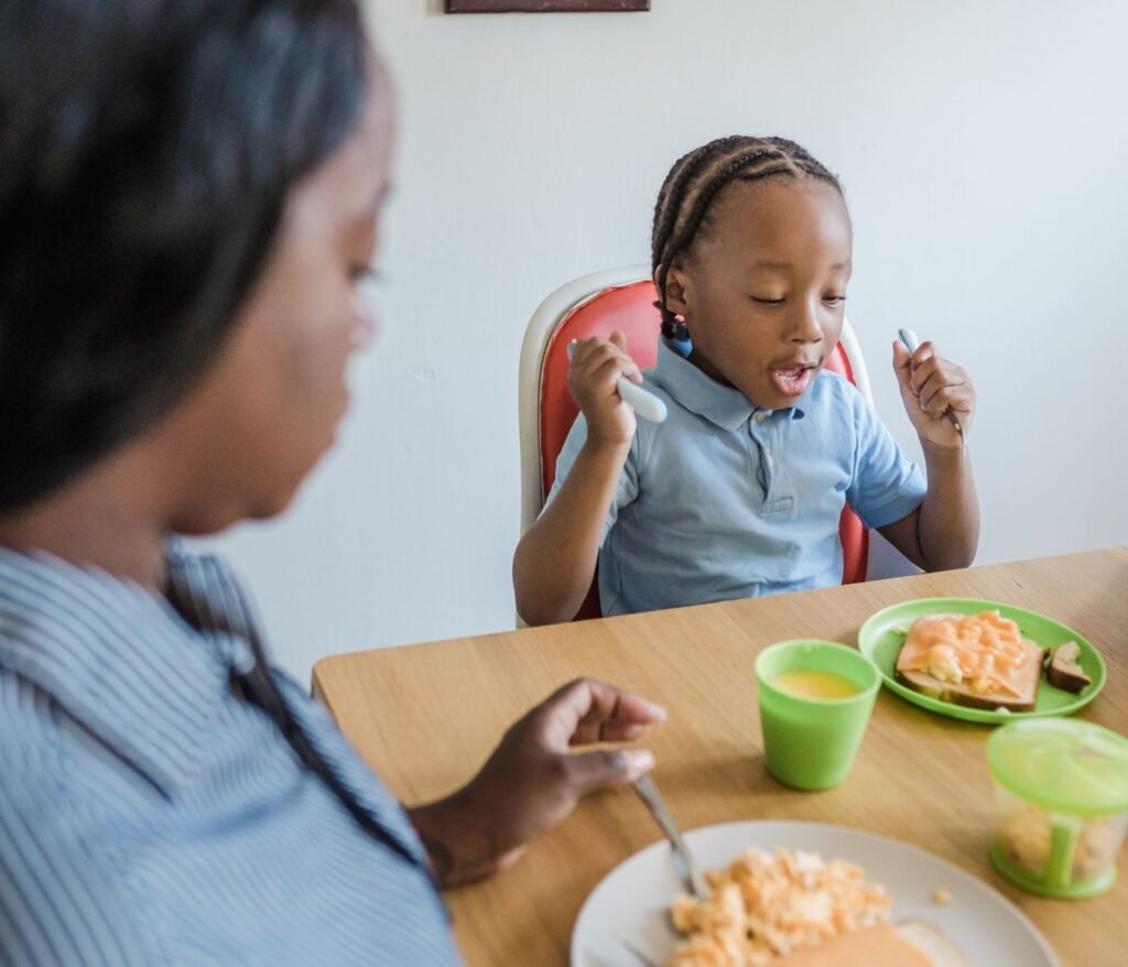 Parent and young child eating a meal together calmly at the table with help from a dietitian for picky eaters